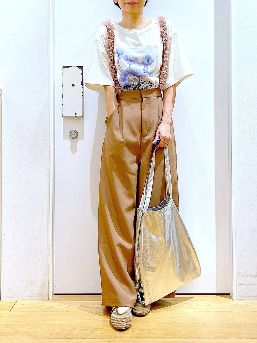 シルバー系のトートバッグ、ベージュ系のパンプス、ブラウン系のその他パンツを着用したレディースの春コーディネートの6枚目の写真