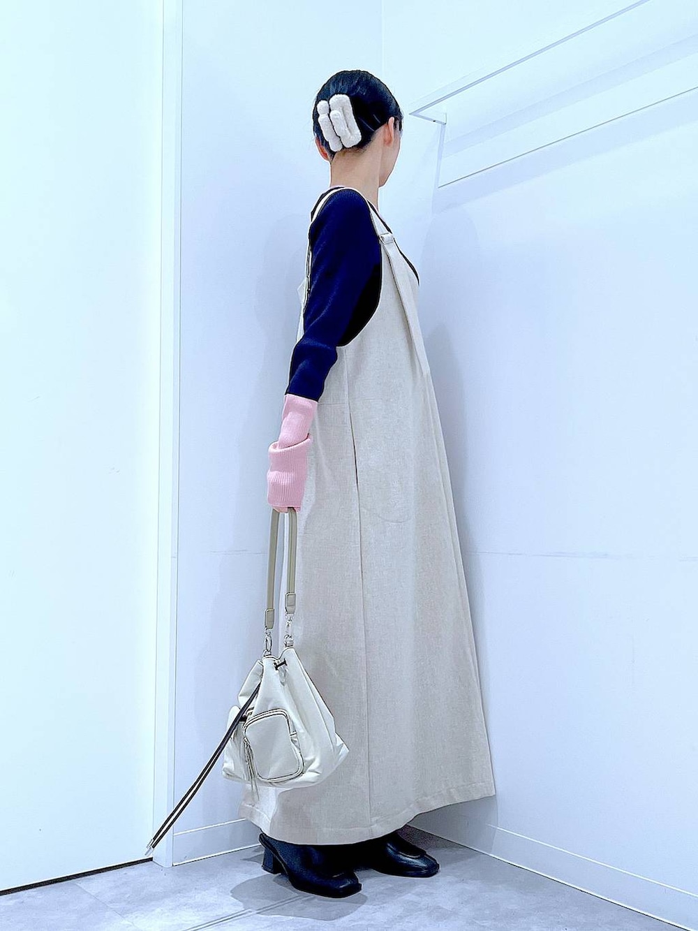 ブラック系のブーツ、ベージュ系のジャンパースカート、ブルー系のニット/セーターを着用したレディースの冬コーディネートの4枚目の写真