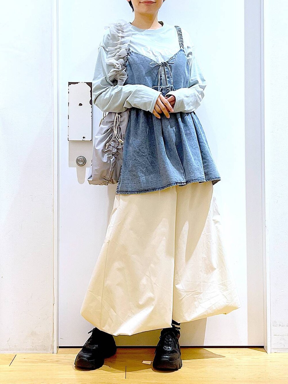 グレー系のショルダーバッグ、ブラック系のスニーカー、ブルー系のその他トップスを着用したレディースの春コーディネートの6枚目の写真