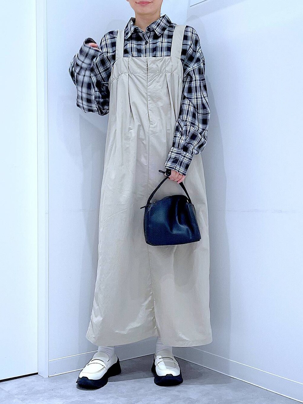 ホワイト系のローファー、ブラック系のショルダーバッグ、グレー系のワンピースを着用したレディースの秋コーディネートの6枚目の写真