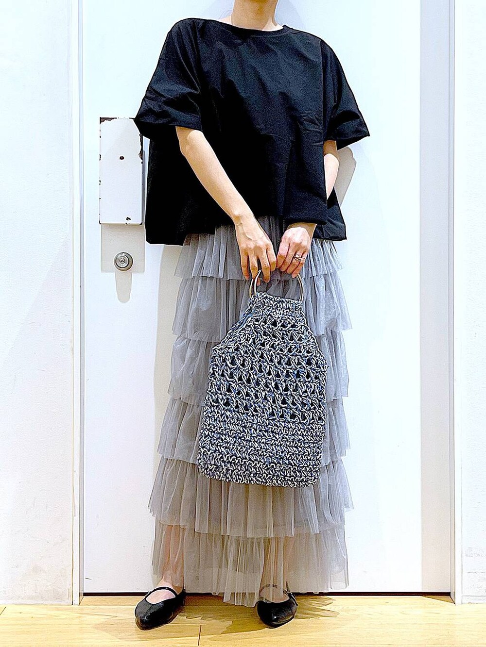 ブラック系のTシャツ/カットソー、ブラック系のパンプス、ブルー系のハンドバッグを着用したレディースの春コーディネートの6枚目の写真