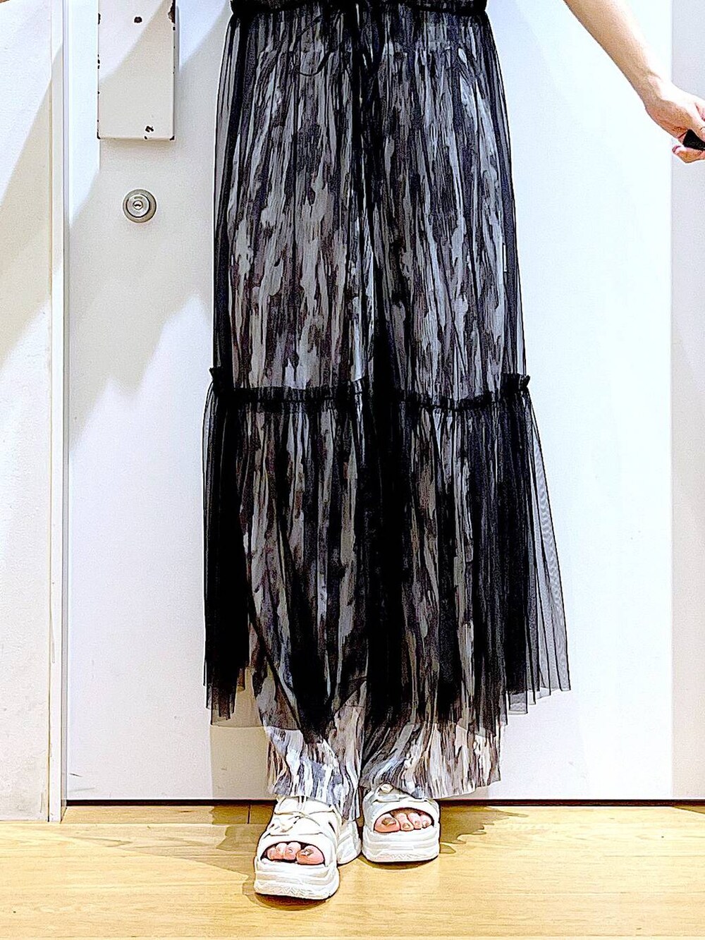 ブラック系のワンピース、ホワイト系のサンダル、ブルー系のトートバッグを着用したレディースの夏コーディネートの8枚目の写真