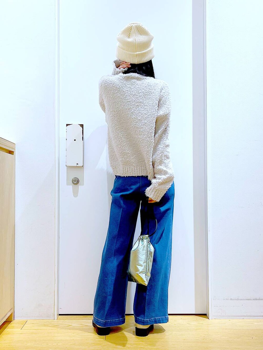 グレー系のニット/セーター、ブルー系のデニムパンツ、ベージュ系のブーツを着用したレディースの冬コーディネートの5枚目の写真