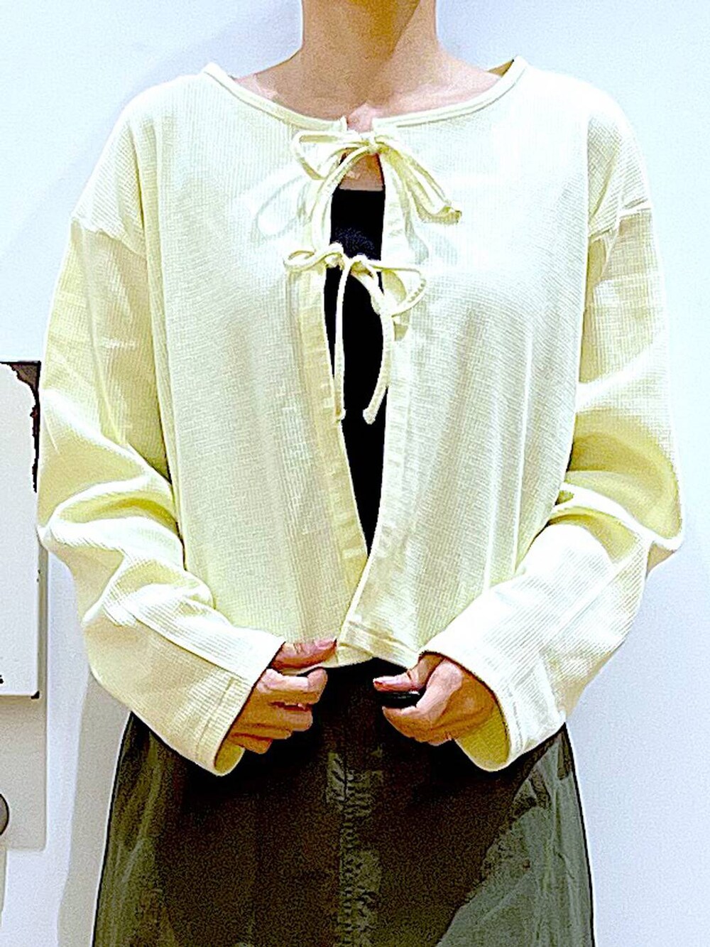 イエロー系のカーディガン/ボレロ、グリーン系のスカート、ベージュ系のトートバッグを着用したレディースの春コーディネートの7枚目の写真