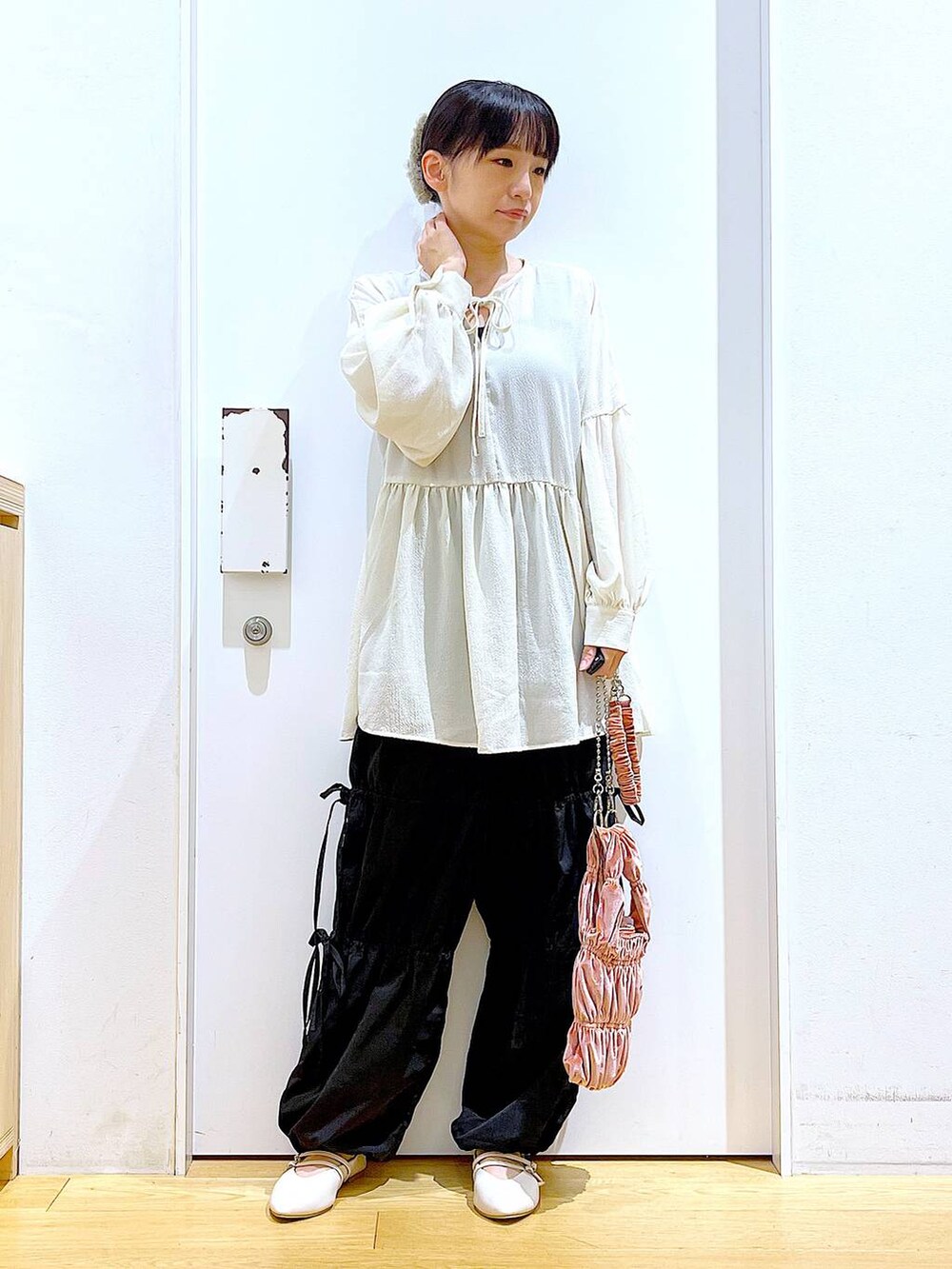 ホワイト系のパンプス、ブラック系のその他パンツ、ホワイト系のチュニックを着用したレディースの秋コーディネートの2枚目の写真