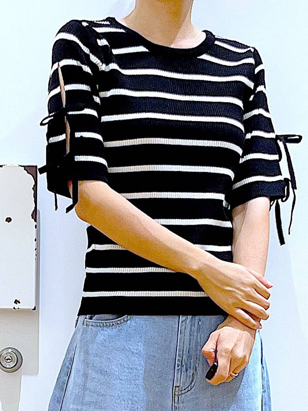 ブラック系のショルダーバッグ、ブラック系のローファー、ブラック系のニット/セーターを着用したレディースの秋コーディネートの7枚目の写真