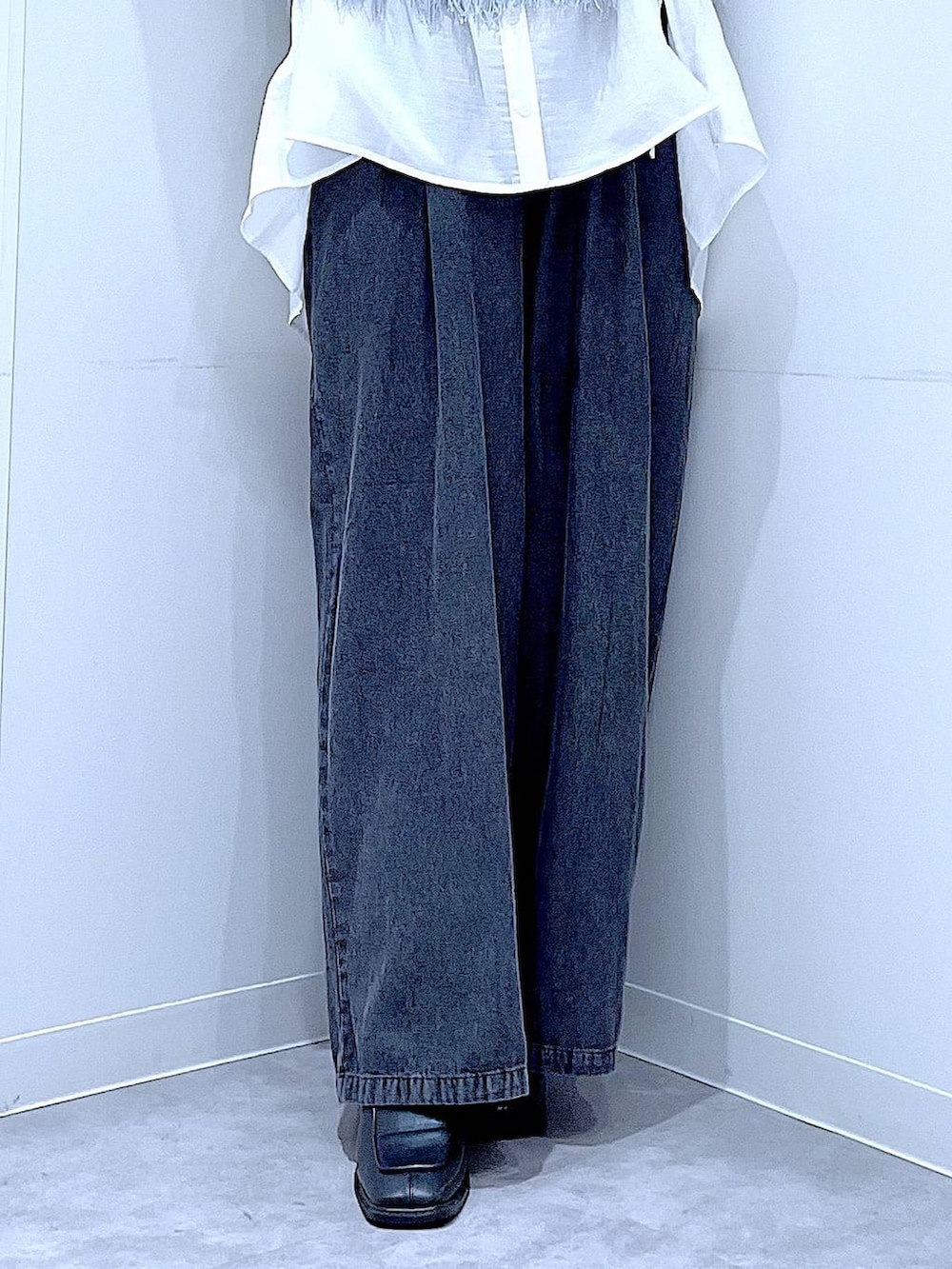 ブラック系のブーツ、ブルー系のベスト、ホワイト系のショルダーバッグを着用したレディースの春コーディネートの8枚目の写真