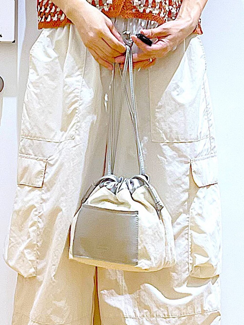 ホワイト系のショルダーバッグ、ホワイト系のカーゴパンツ、ホワイト系のサンダルを着用したレディースの夏コーディネートの9枚目の写真