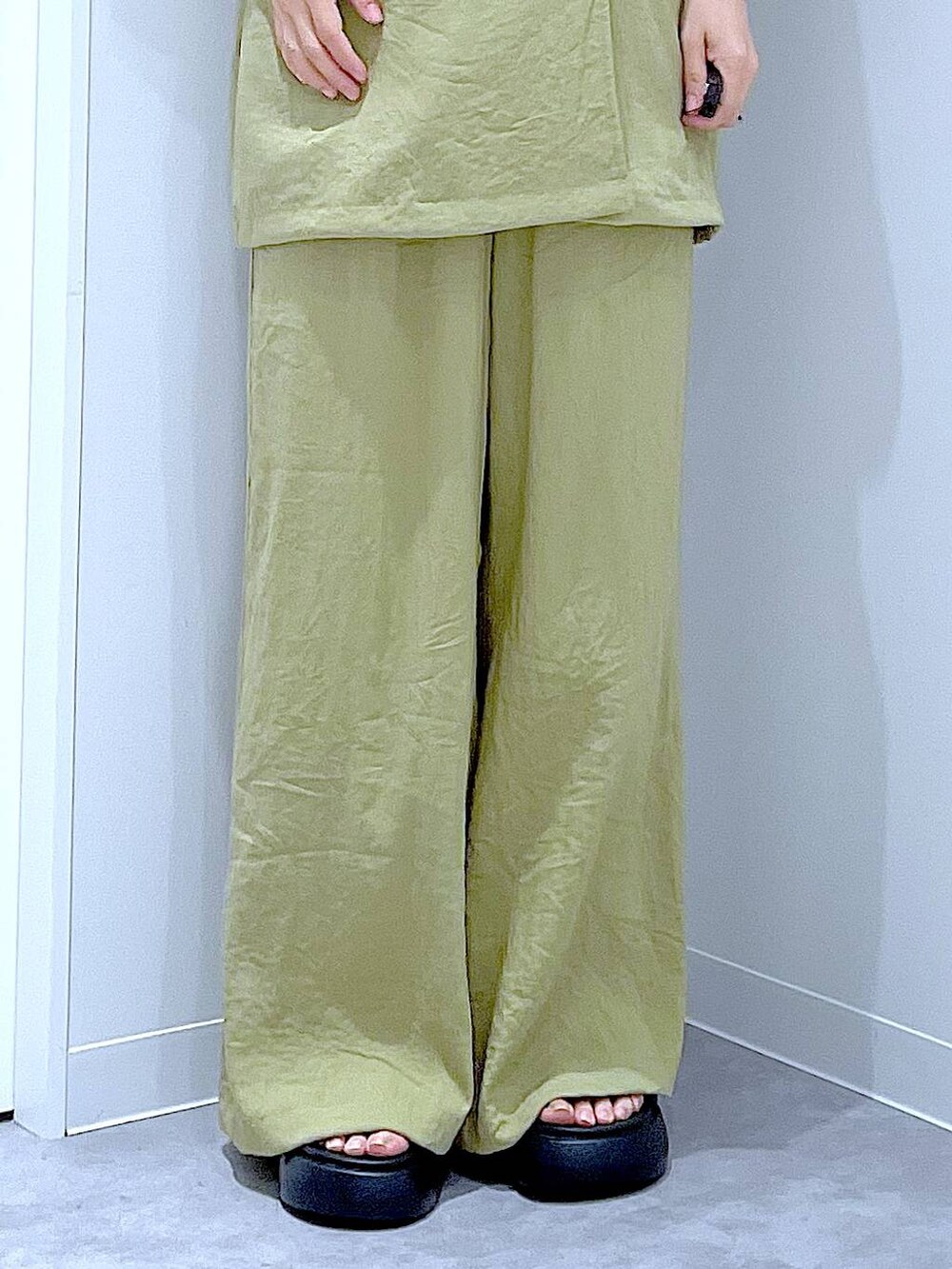 ホワイト系のショルダーバッグ、ブラック系のサンダル、グリーン系のテーラードジャケットを着用したレディースの夏コーディネートの8枚目の写真