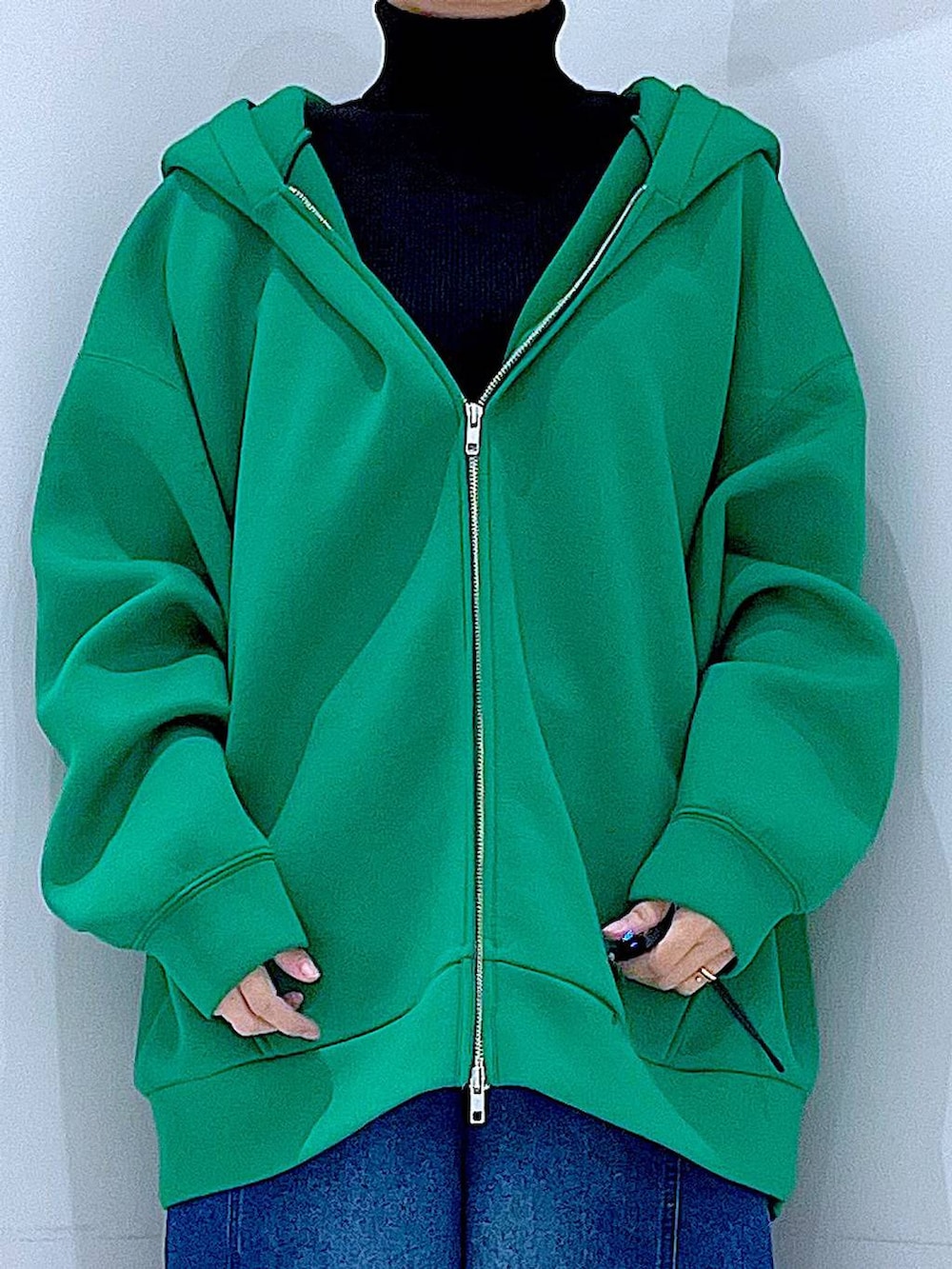 ブラック系のショルダーバッグ、ブラック系のニット/セーター、ブルー系のデニムパンツを着用したレディースの冬コーディネートの7枚目の写真