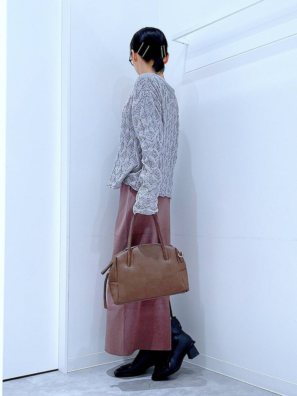 ブラウン系のボストンバッグ、ブラック系のブーツ、グレー系のカーディガン/ボレロを着用したレディースの冬コーディネートの3枚目の写真