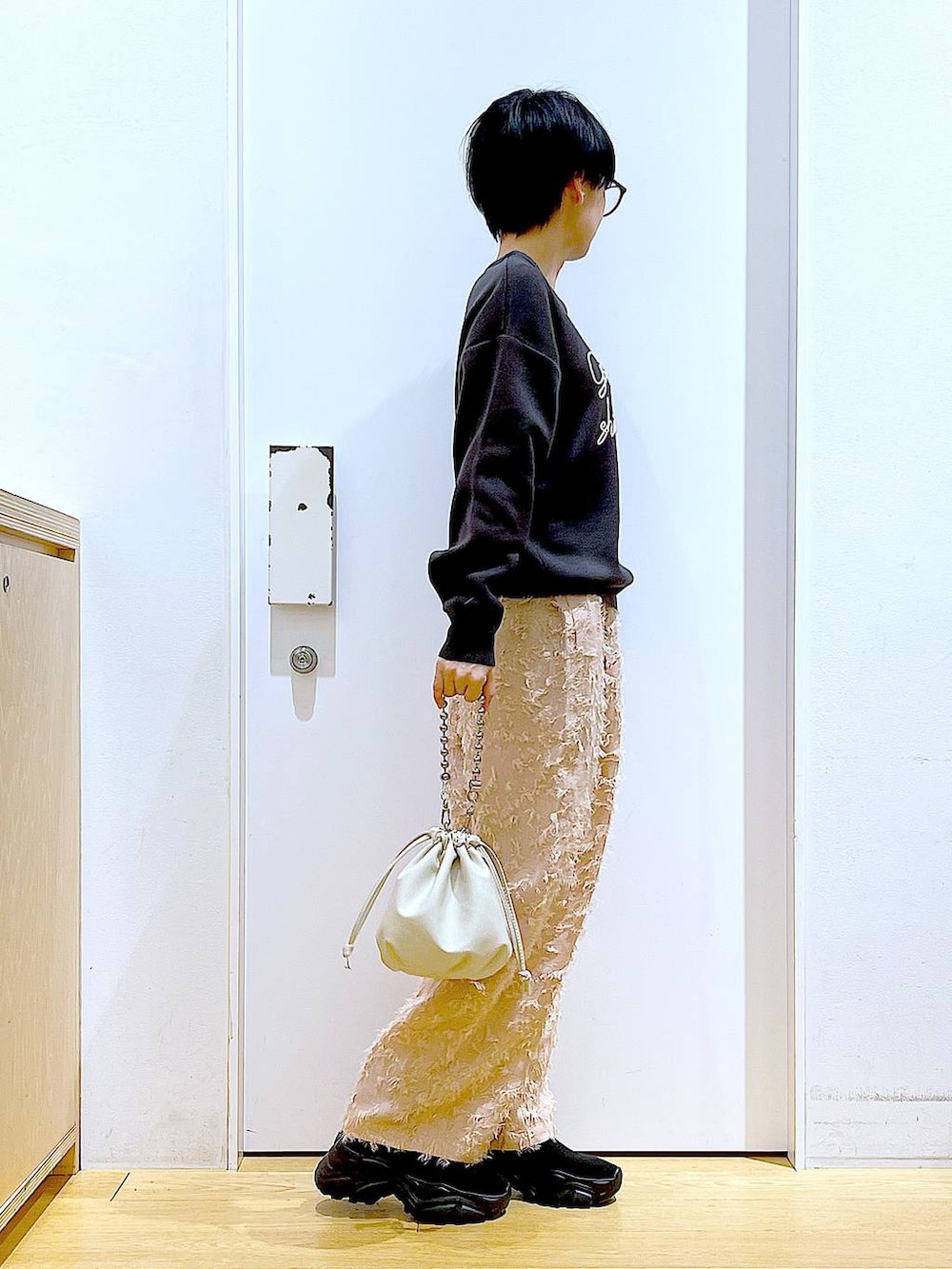 ベージュ系のショルダーバッグ、ブラック系のブーツ、グレー系のニット/セーターを着用したレディースの春コーディネートの4枚目の写真