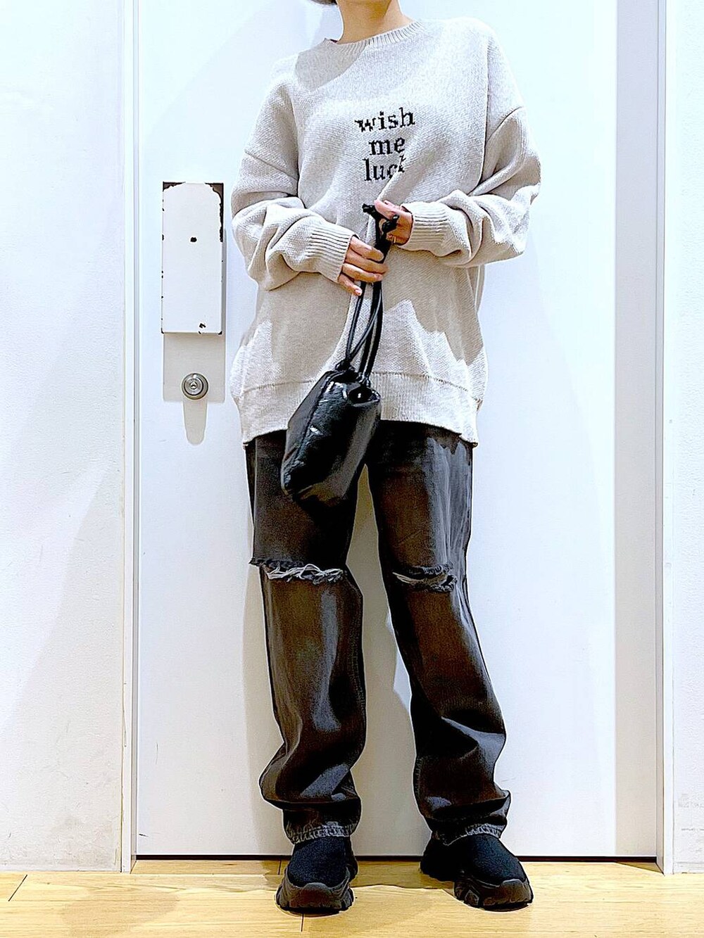 ブラック系のブーツ、ベージュ系のニット/セーター、ブルー系のデニムパンツを着用したレディースの冬コーディネートの6枚目の写真