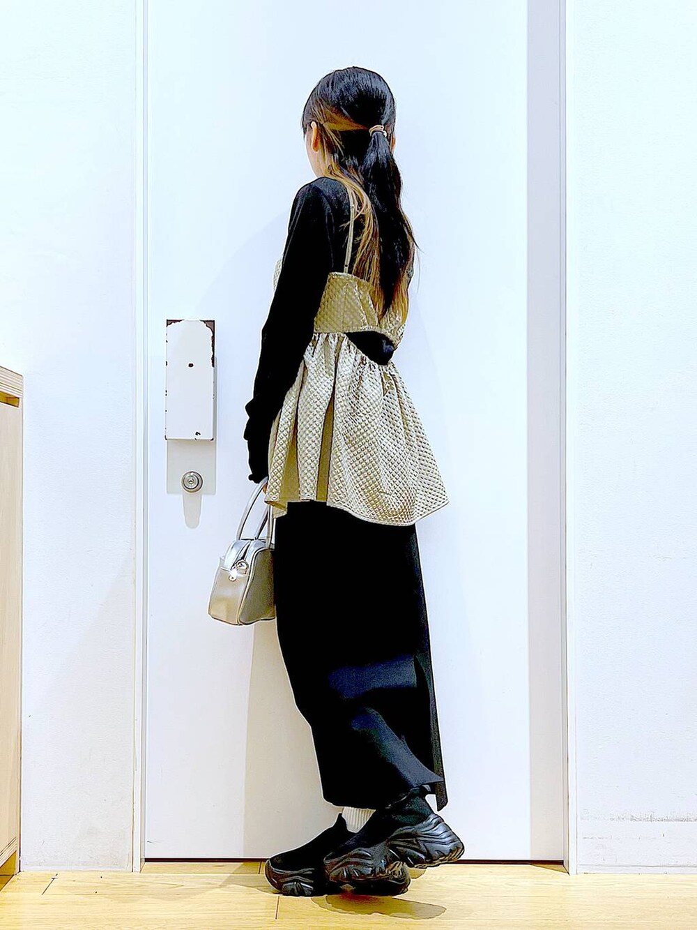 シルバー系のショルダーバッグ、ブラック系のTシャツ/カットソー、ブラック系のスニーカーを着用したレディースの春コーディネートの3枚目の写真