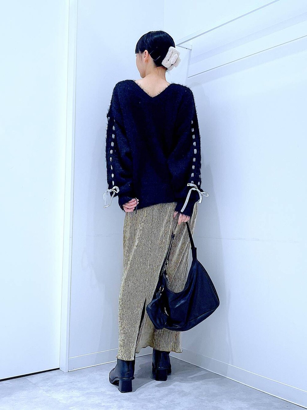 ブラック系のブーツ、ブラック系のニット/セーター、ブラック系のショルダーバッグを着用したレディースの冬コーディネートの5枚目の写真