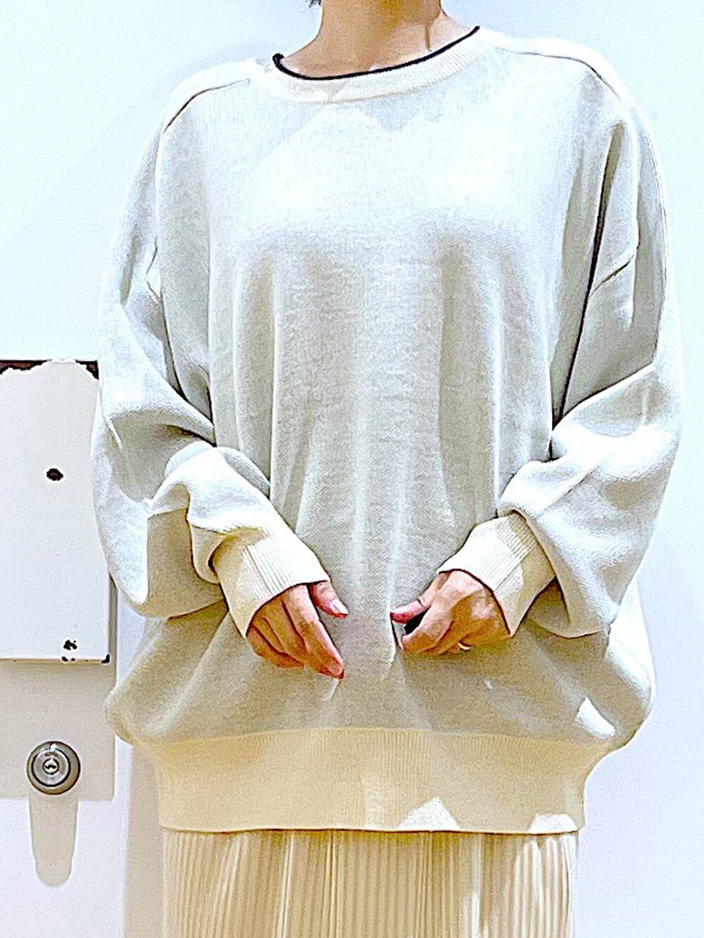 ベージュ系のニット/セーター、レッド系のショルダーバッグ、ベージュ系のブーツを着用したレディースの冬コーディネートの7枚目の写真