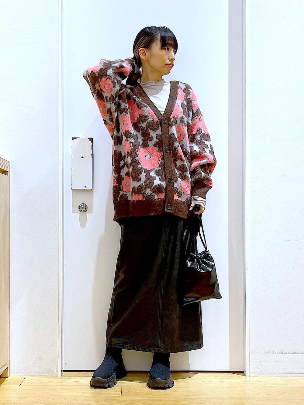 グレー系のTシャツ/カットソー、ブラック系のブーツ、ブラック系のスカートを着用したレディースの冬コーディネートの2枚目の写真