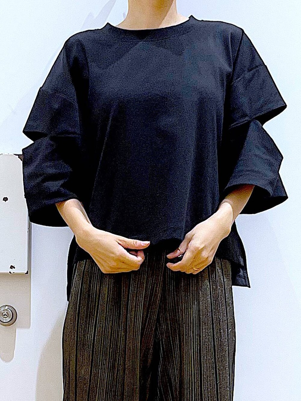 ブラック系のサンダル、ブルー系のトートバッグ、ブラック系のTシャツ/カットソーを着用したレディースの秋コーディネートの7枚目の写真