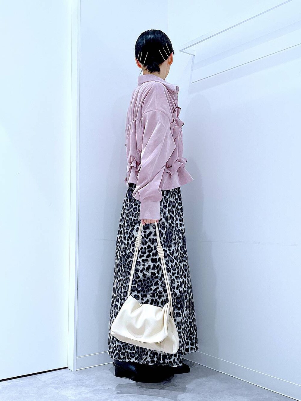 ホワイト系のショルダーバッグ、ブラック系のブーツ、グレー系のスカートを着用したレディースの秋コーディネートの4枚目の写真