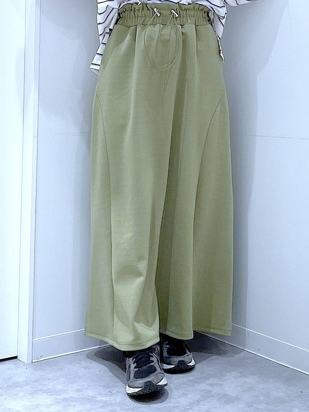 ブラック系のショルダーバッグ、グリーン系のスカート、ホワイト系のTシャツ/カットソーを着用したレディースの冬コーディネートの8枚目の写真