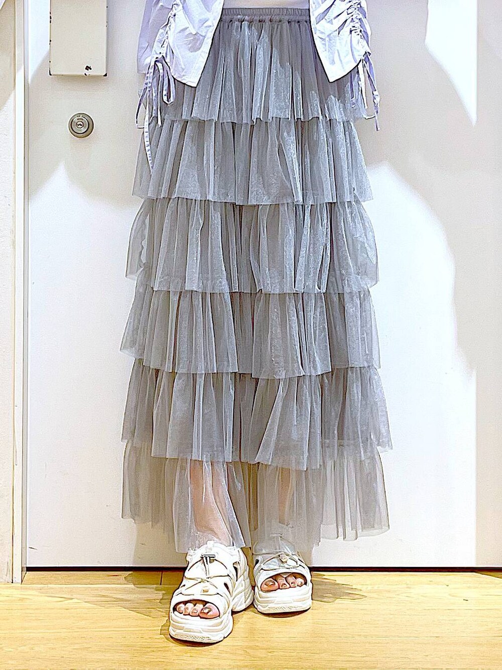 ブルー系のショルダーバッグ、ホワイト系のサンダル、グレー系のスカートを着用したレディースの夏コーディネートの8枚目の写真