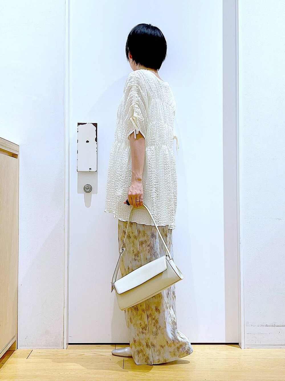 シルバー系のパンプス、ホワイト系のショルダーバッグ、ベージュ系のその他パンツを着用したレディースの春コーディネートの3枚目の写真