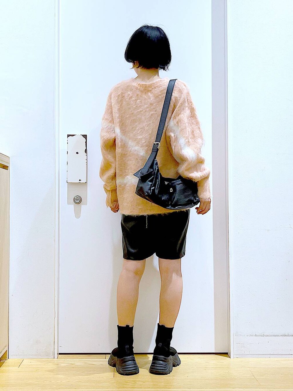 ピンク系のニット/セーター、ブラック系のブーツ、ブラック系のショルダーバッグを着用したレディースの冬コーディネートの5枚目の写真