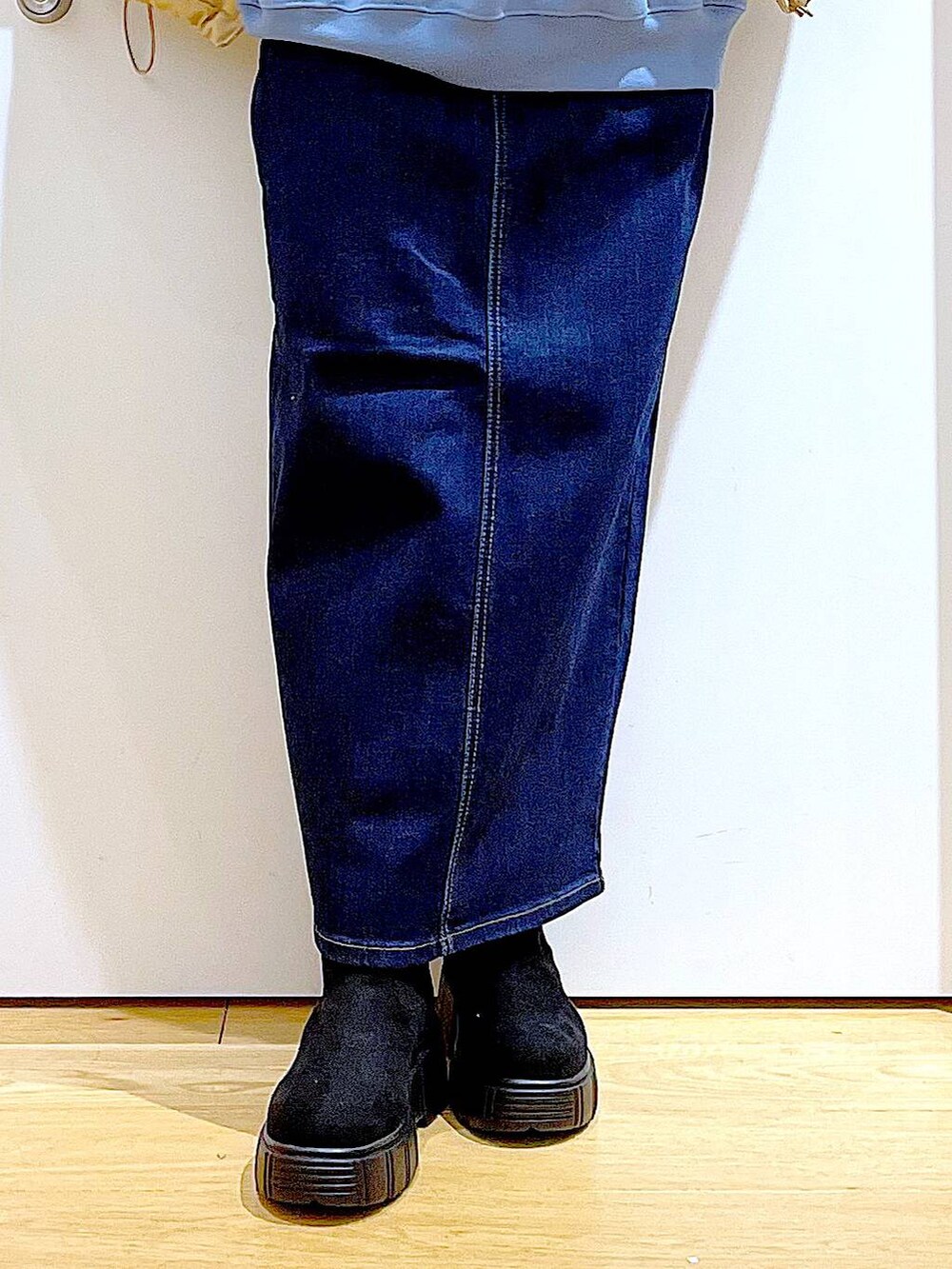 シルバー系のトートバッグ、ベージュ系のナイロンジャケット、ブルー系のデニムスカートを着用したレディースの冬コーディネートの8枚目の写真