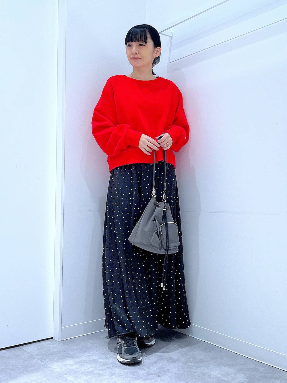 レッド系のスウェット、グレー系のシュシュを着用したレディースの春コーディネートの2枚目の写真