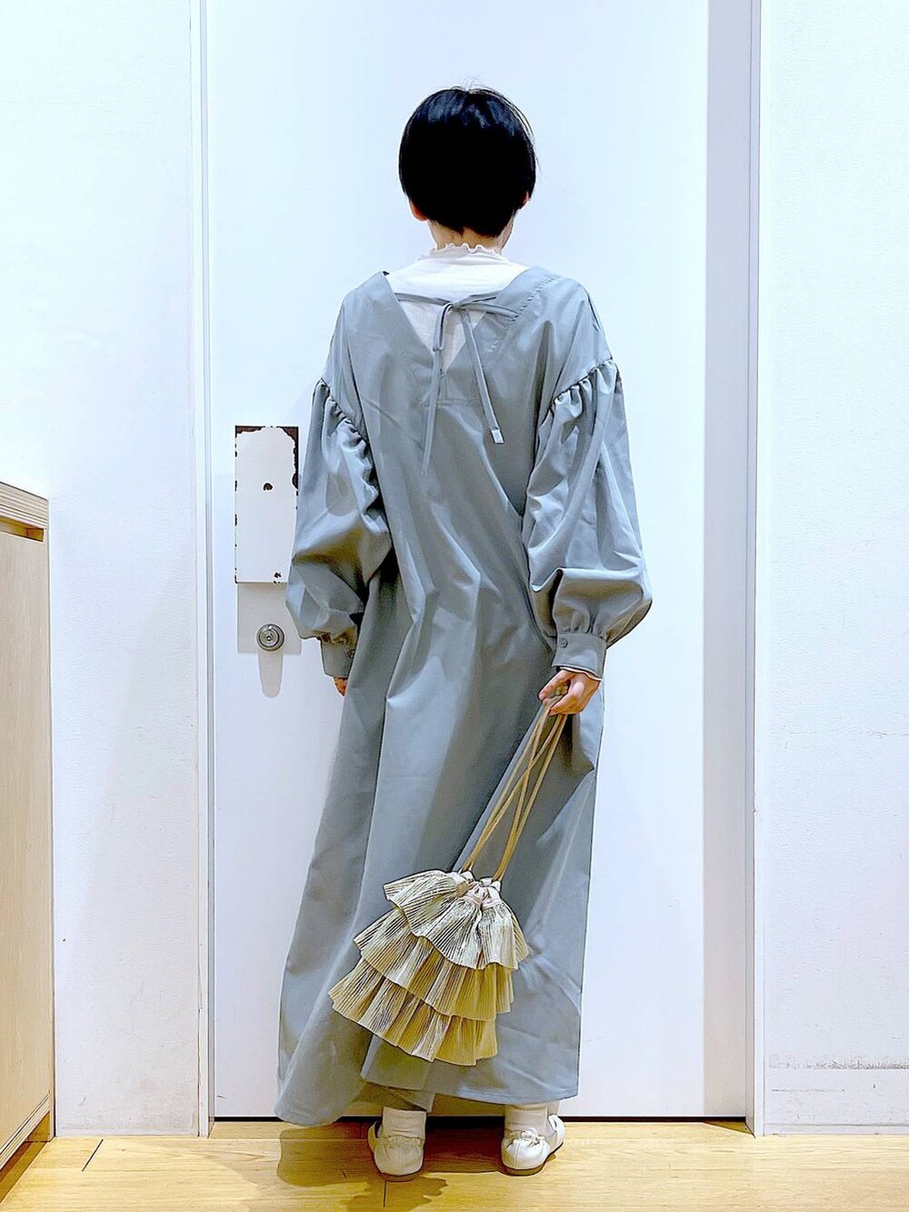 ベージュ系のTシャツ/カットソー、ホワイト系のパンプス、ベージュ系のショルダーバッグを着用したレディースの春コーディネートの5枚目の写真