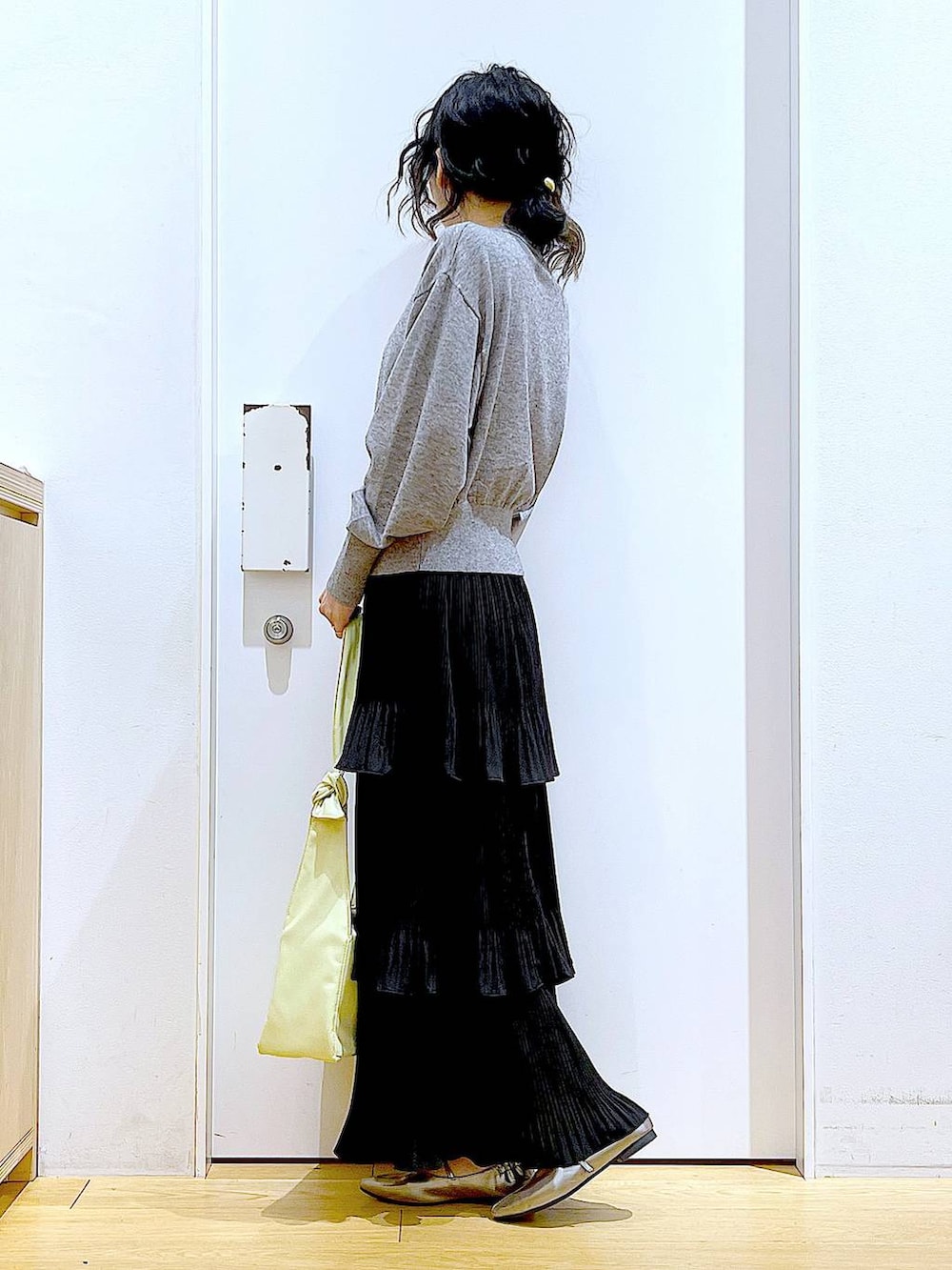 ブラック系のカーディガン/ボレロ、ブラック系のスカート、イエロー系のショルダーバッグを着用したレディースの春コーディネートの3枚目の写真