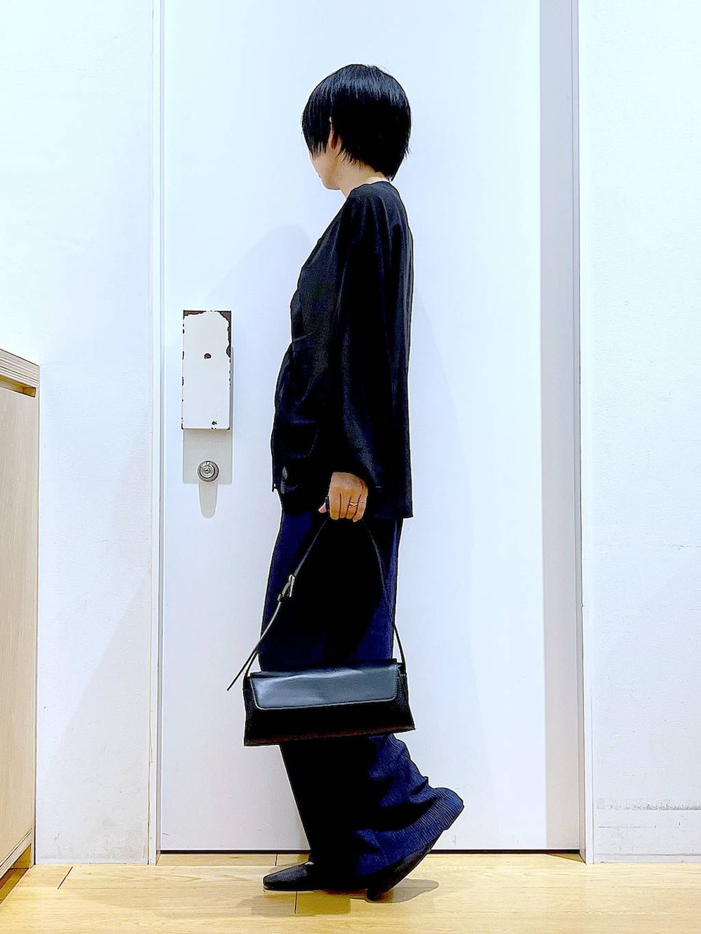 ブラック系のパンプス、ブラック系のショルダーバッグ、ブラック系のシャツ/ブラウスを着用したレディースの夏コーディネートの3枚目の写真