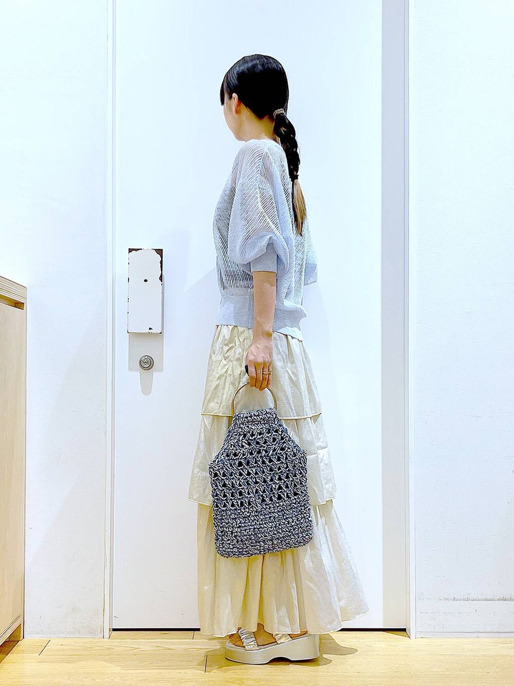 シルバー系のサンダル、ブルー系のハンドバッグ、ゴールド系のスカートを着用したレディースの夏コーディネートの3枚目の写真