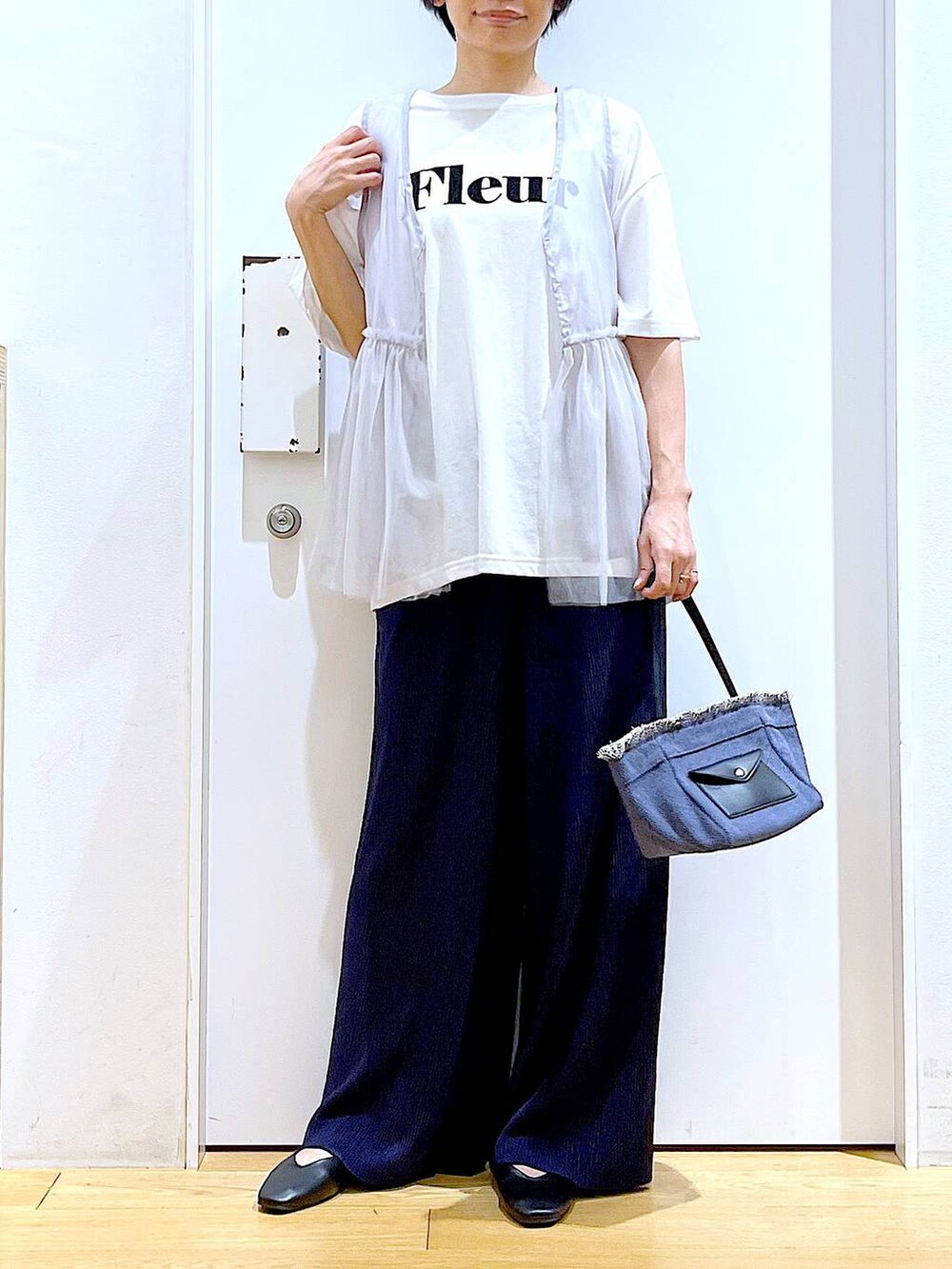 ブラック系のパンプス、ブルー系のショルダーバッグ、ホワイト系のTシャツ/カットソーを着用したレディースの夏コーディネートの6枚目の写真