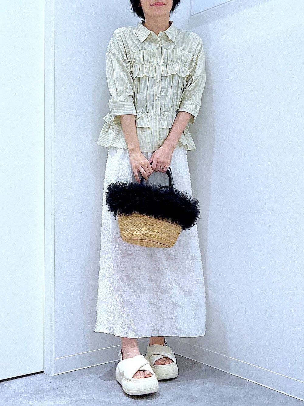 ベージュ系のショルダーバッグ、ホワイト系のサンダル、ホワイト系のスカートを着用したレディースの夏コーディネートの6枚目の写真