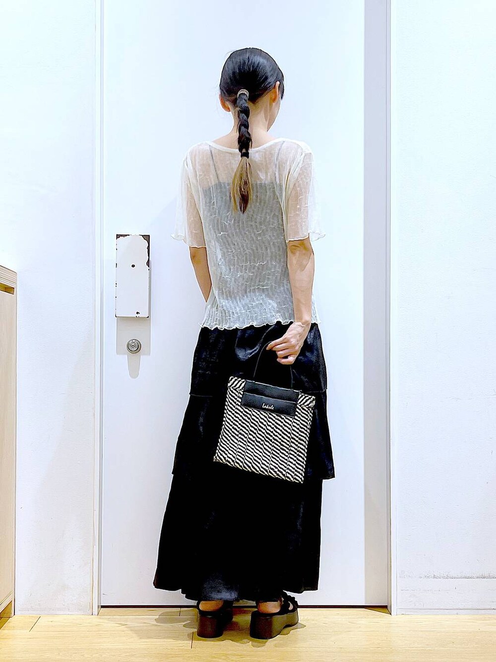 ブラック系のサンダル、ブラック系のショルダーバッグ、ブラック系のスカートを着用したレディースの夏コーディネートの5枚目の写真