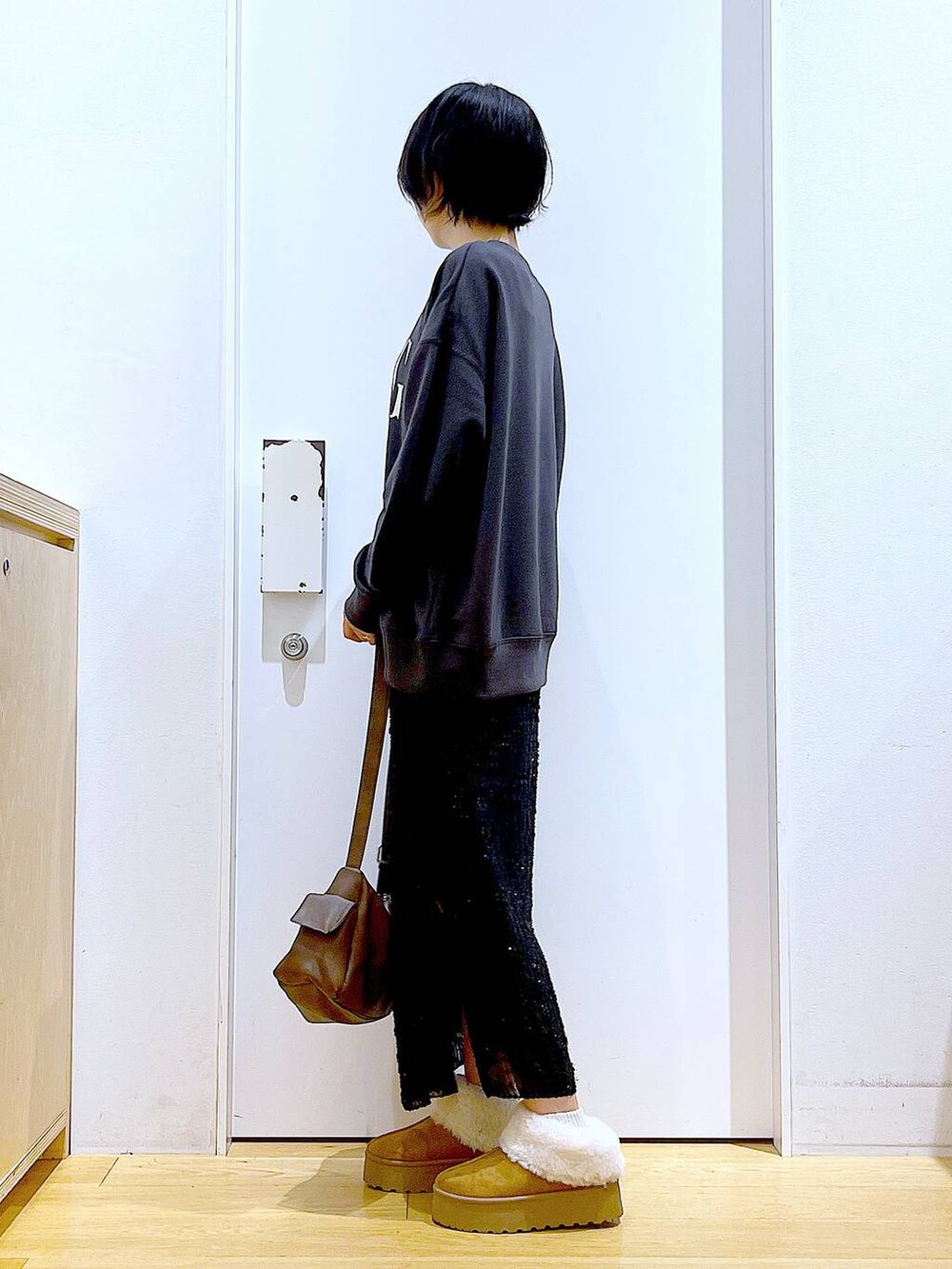 ベージュ系のスリッポン、ブラック系のスカート、グレー系のスウェットを着用したレディースの秋コーディネートの3枚目の写真