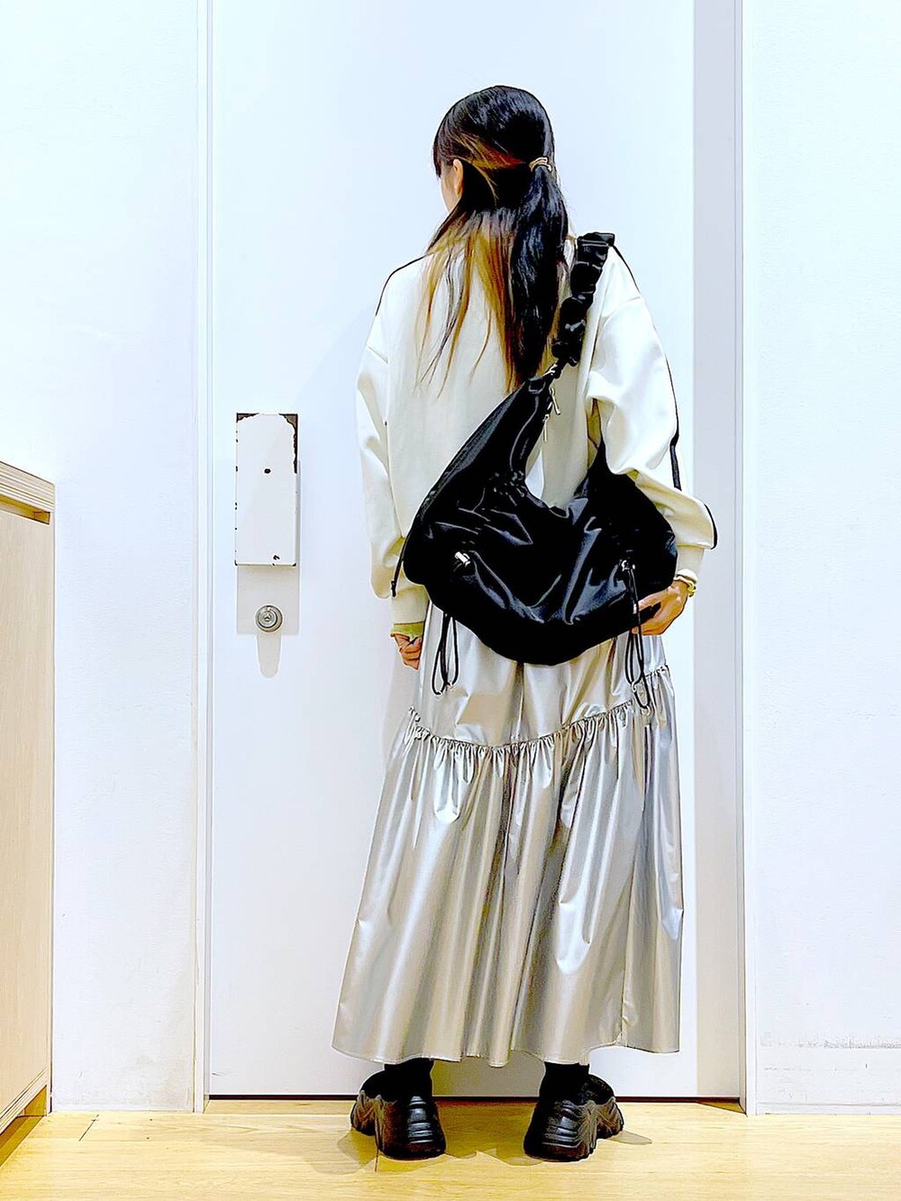 グリーン系のTシャツ/カットソー、ベージュ系のブルゾン、ブラック系のスニーカーを着用したレディースの春コーディネートの5枚目の写真