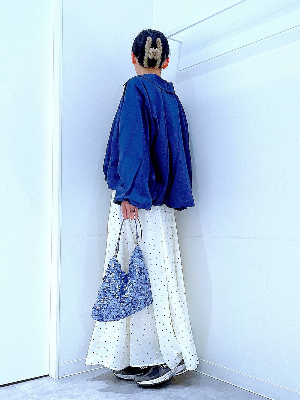 ブルー系のブルゾン、ブラック系のTシャツ/カットソー、ホワイト系のスカートを着用したレディースの春コーディネートの3枚目の写真