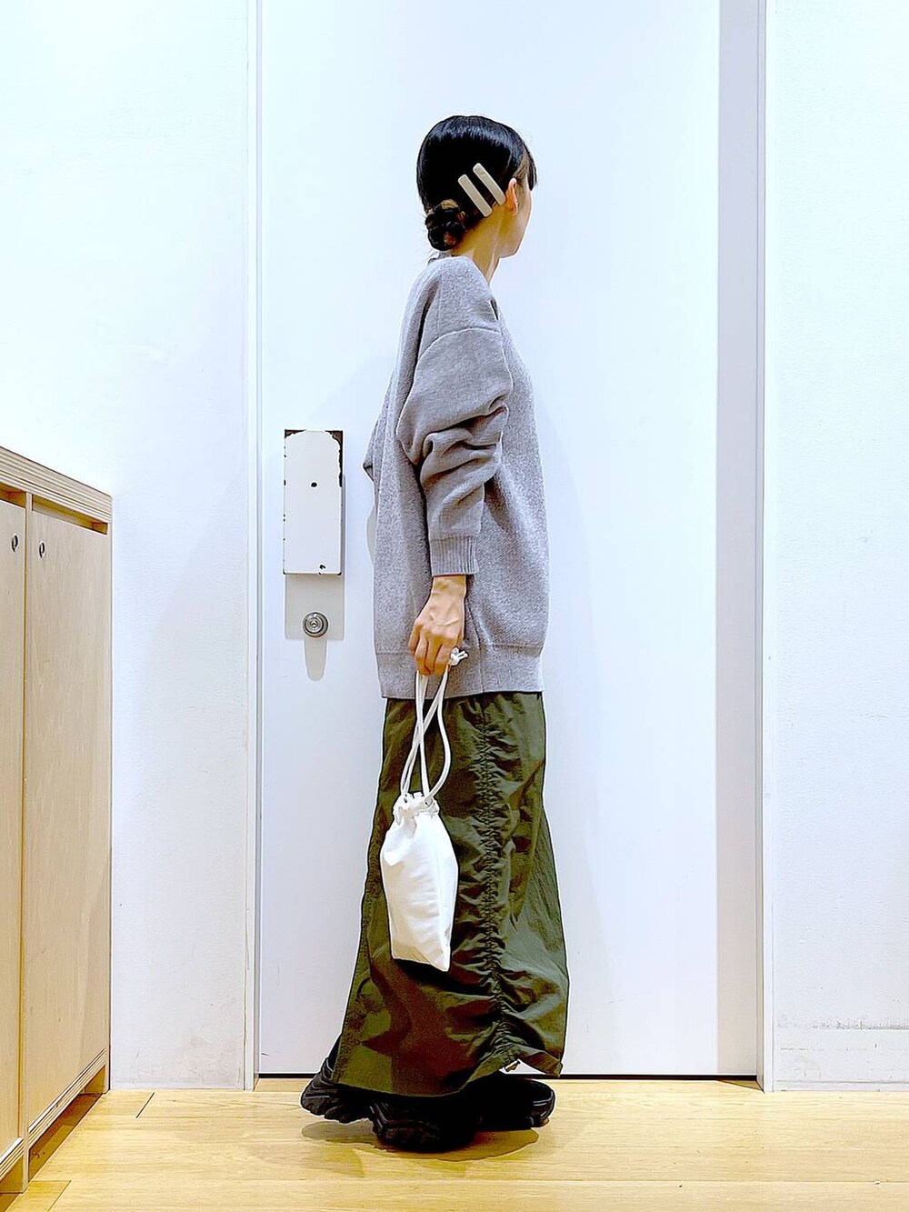 ブラック系のブーツ、グレー系のニット/セーター、グリーン系のスカートを着用したレディースの冬コーディネートの4枚目の写真