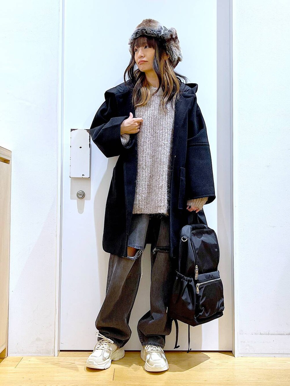 ブラック系のバックパック/リュック、ブラック系のその他アウター、ベージュ系のスニーカーを着用したレディースの冬コーディネートの2枚目の写真