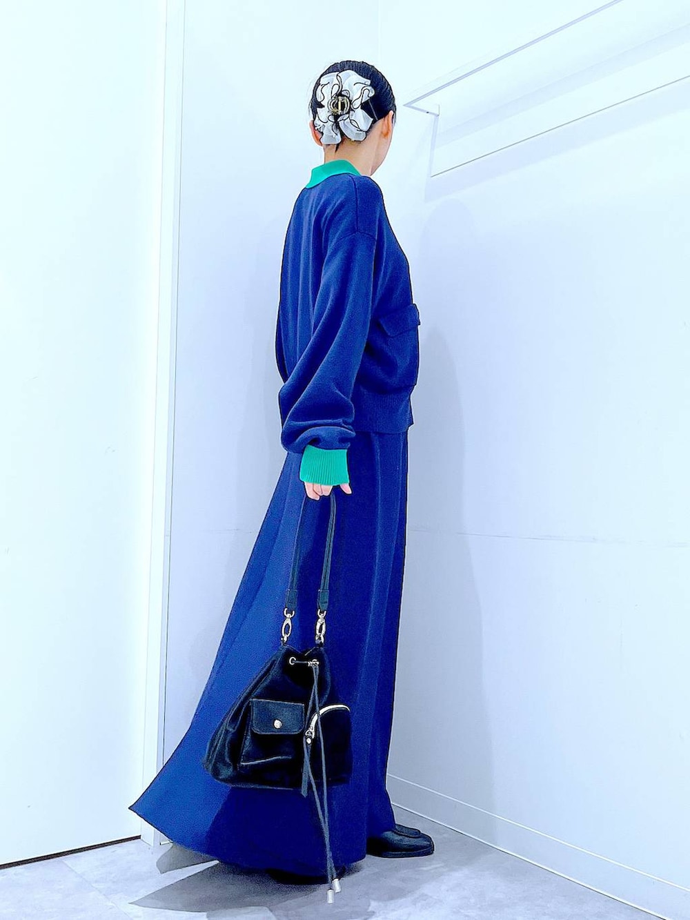 ブラック系のショルダーバッグ、ブラック系のブーツ、ブルー系のスカートを着用したレディースの冬コーディネートの4枚目の写真