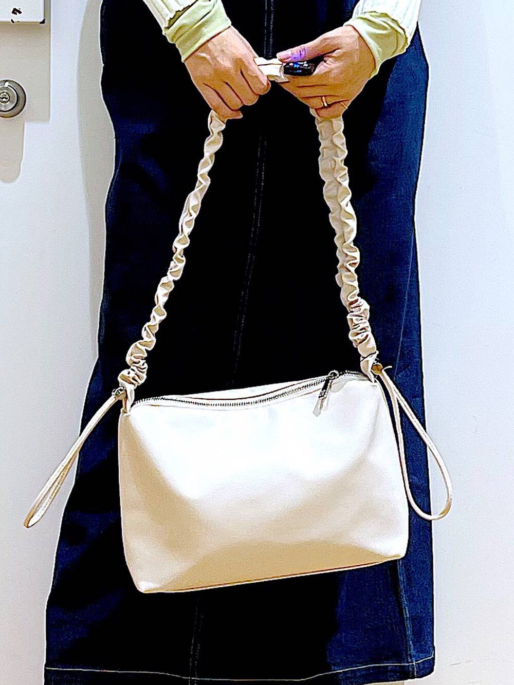 ブルー系のジャンパースカート、ベージュ系のカーディガン/ボレロ、グリーン系のその他トップスを着用したレディースの春コーディネートの9枚目の写真