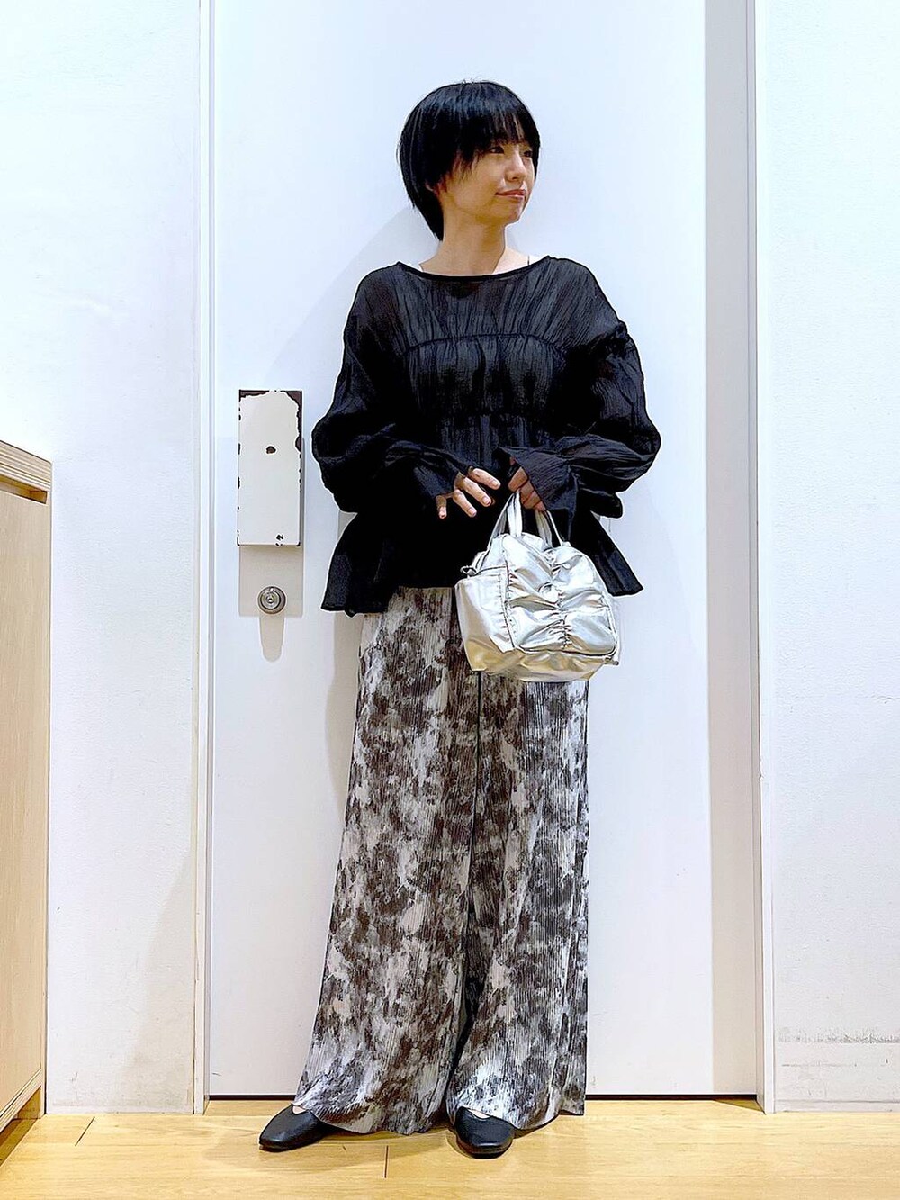 ブラック系のパンプス、その他のショルダーバッグ、ブラック系のシャツ/ブラウスを着用したレディースの夏コーディネートの2枚目の写真