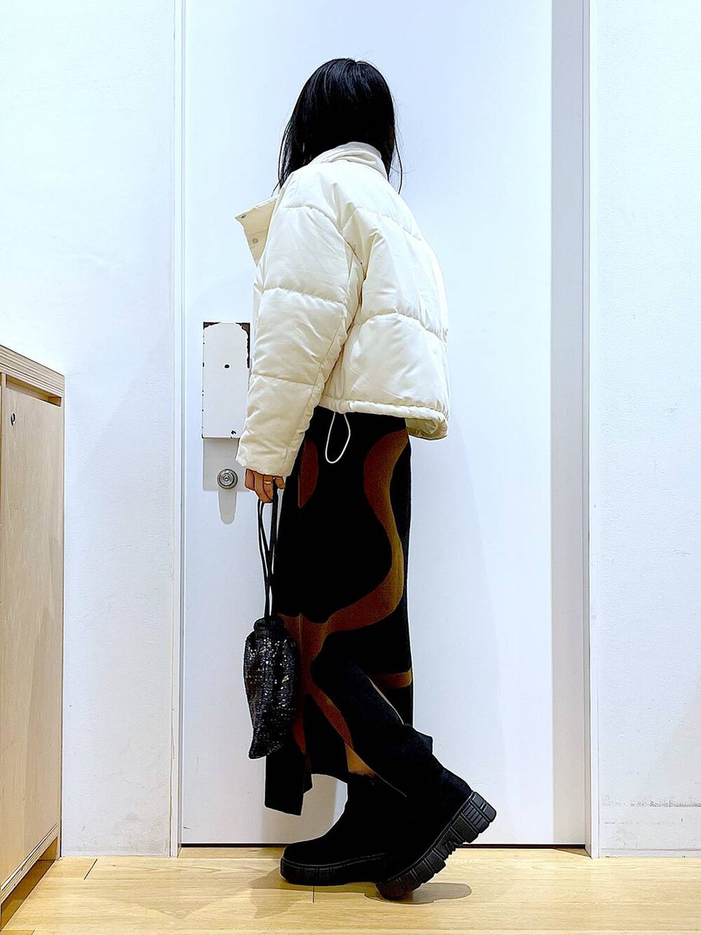 その他のスカート、ブラック系のショルダーバッグ、ブラック系のブーツを着用したレディースの冬コーディネートの3枚目の写真