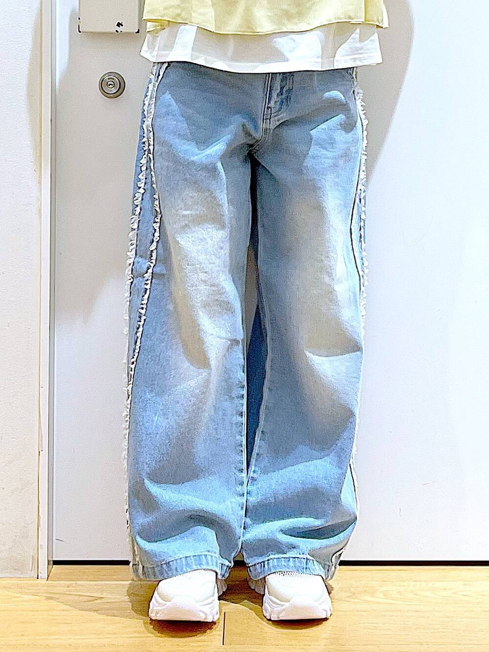 ホワイト系のスニーカー、ブルー系のデニムパンツ、ベージュ系のその他トップスを着用したレディースの春コーディネートの8枚目の写真
