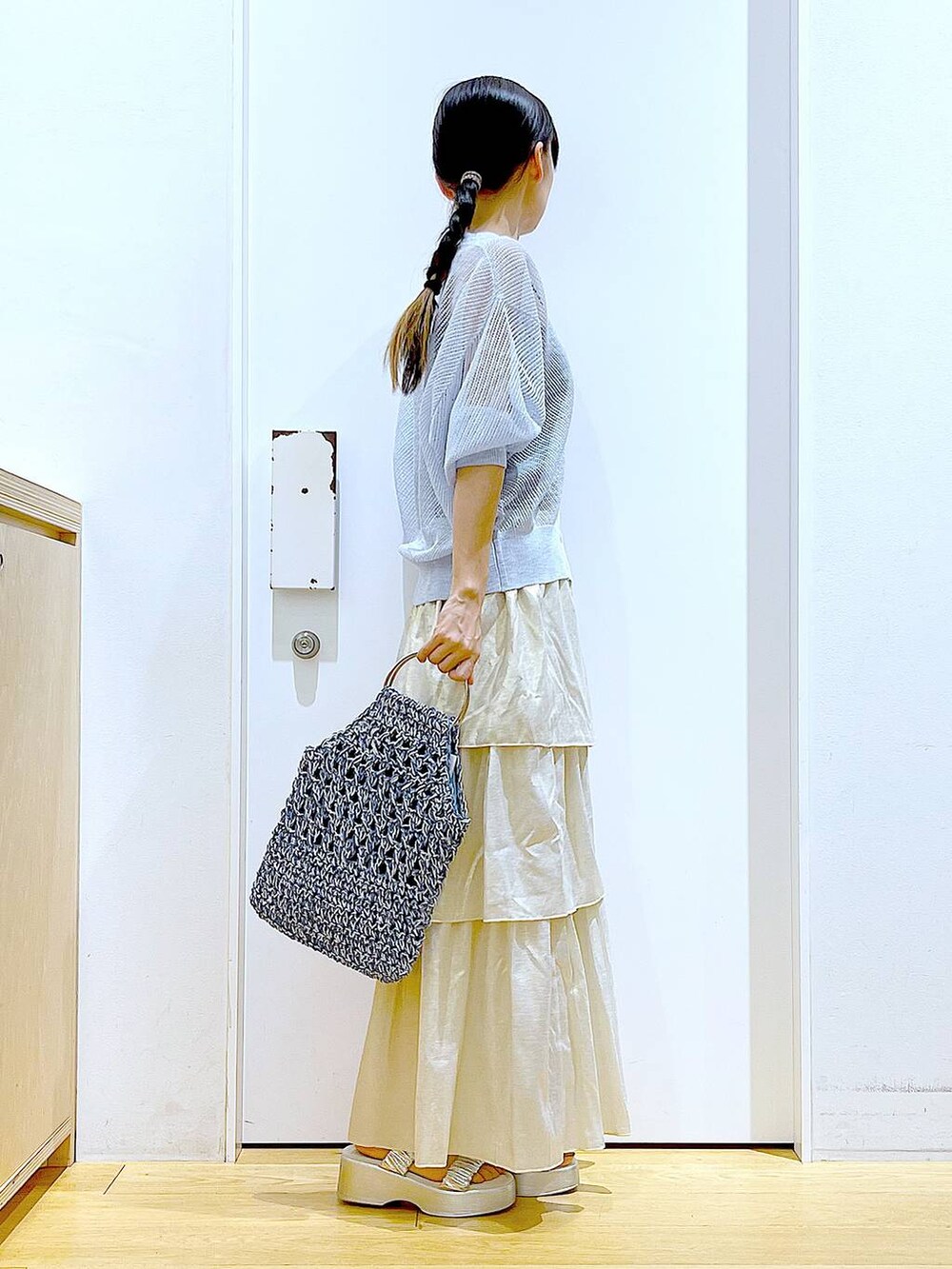 シルバー系のサンダル、ブルー系のハンドバッグ、ゴールド系のスカートを着用したレディースの夏コーディネートの4枚目の写真