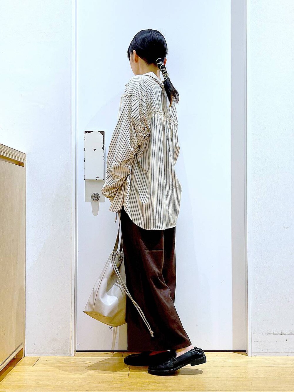 ベージュ系のトートバッグ、ブラック系のローファー、ブラウン系のその他パンツを着用したレディースの秋コーディネートの3枚目の写真