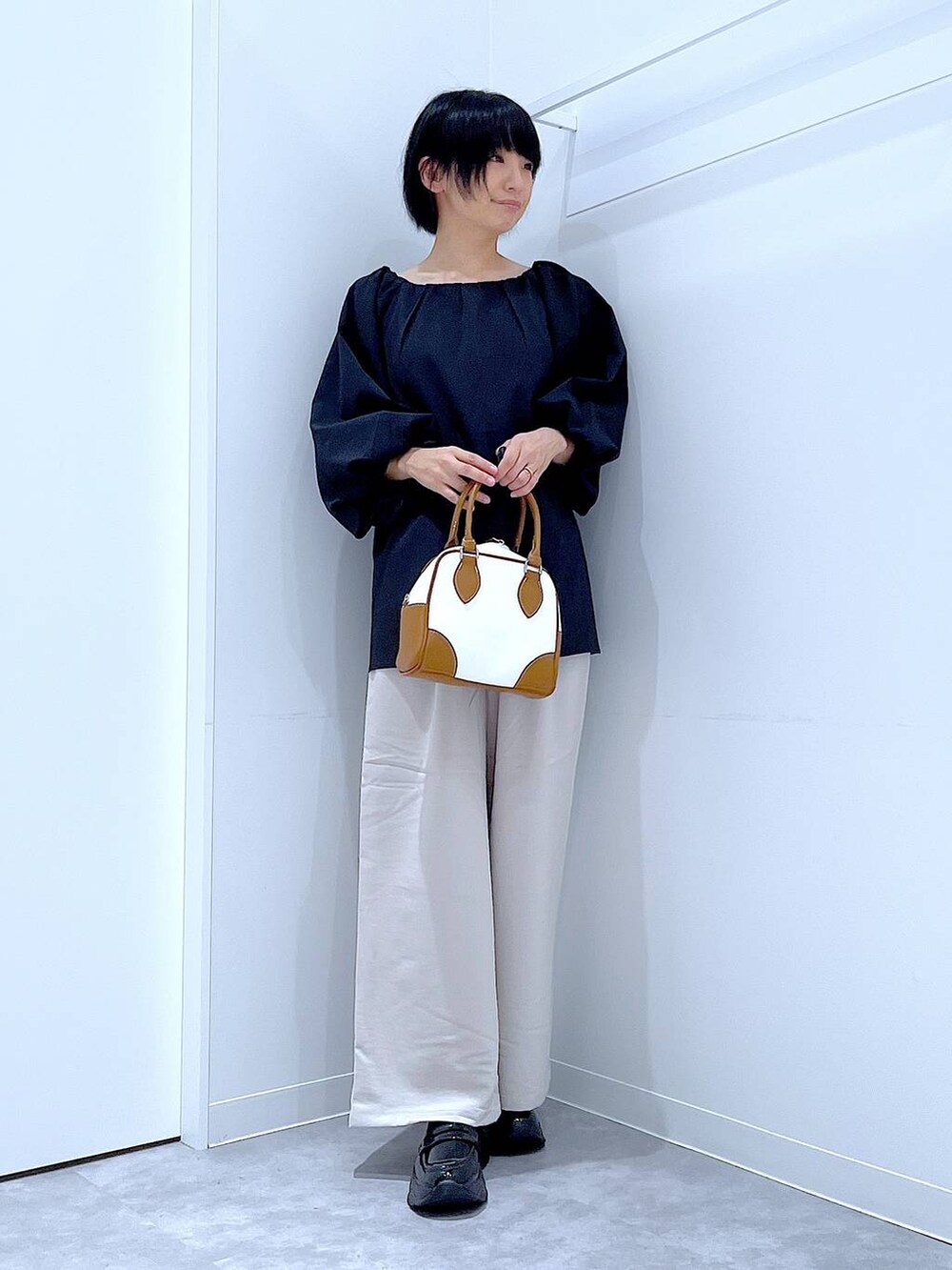 ベージュ系のその他パンツ、ブラック系のローファー、ブラック系のシャツ/ブラウスを着用したレディースの秋コーディネートの2枚目の写真