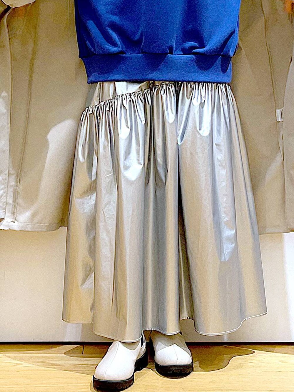 ベージュ系のその他アウター、シルバー系のスカート、ブルー系のスウェットを着用したレディースの春コーディネートの8枚目の写真